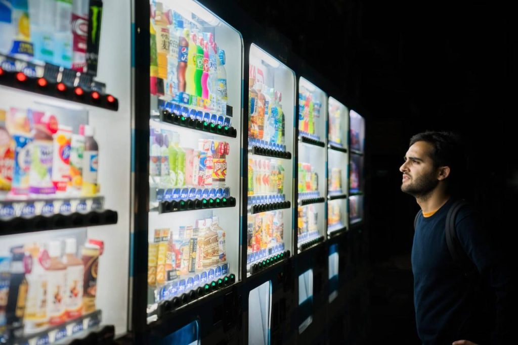 Image of man looking at vending machines trying to decide what to purchase