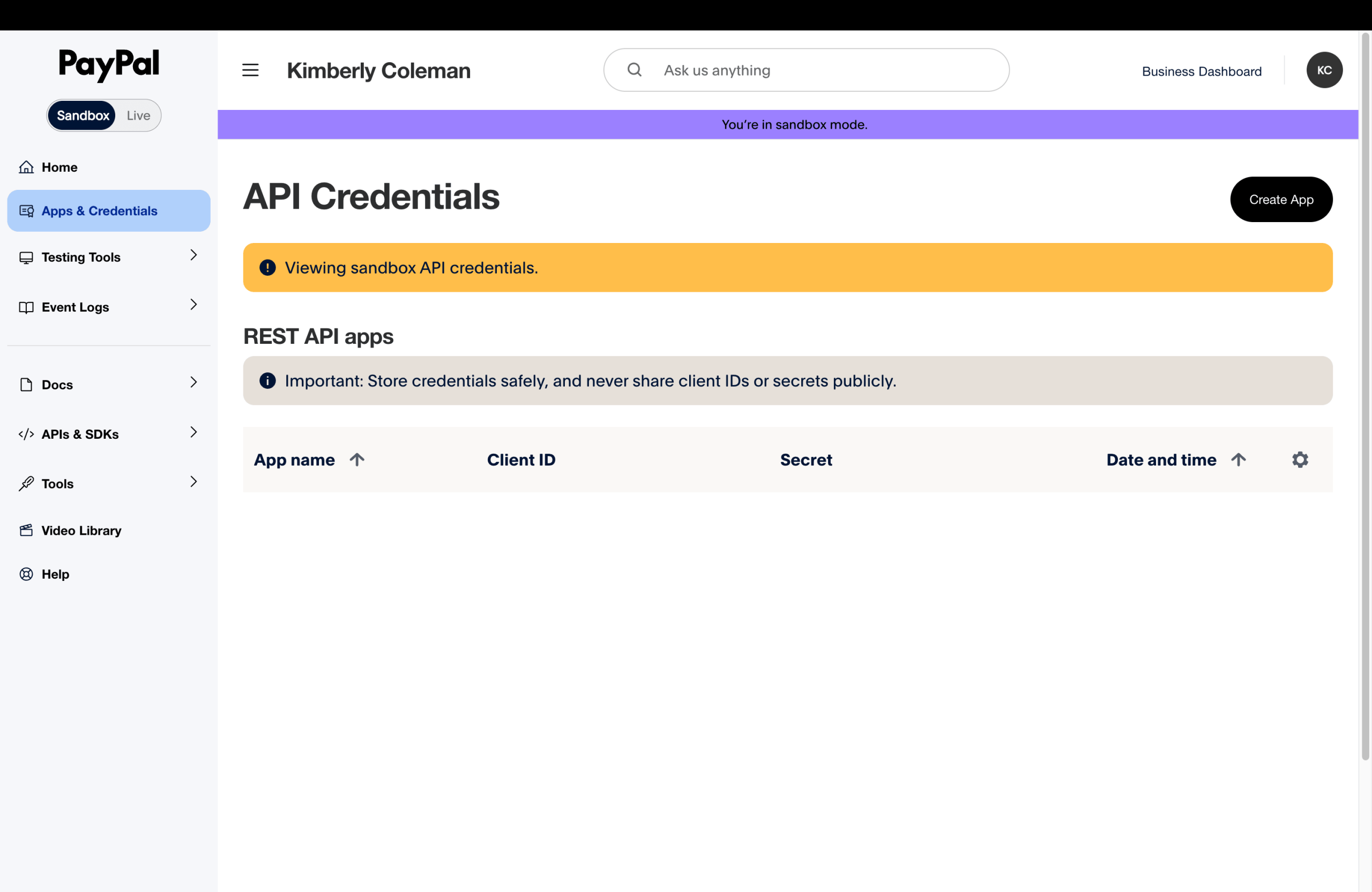 PayPal Developer Dashboard Apps & Credentials page in Sandbox mode with an empty REST API apps table showing App name, Client ID, Secret, and Date and time columns, and a Create App button in the upper right.